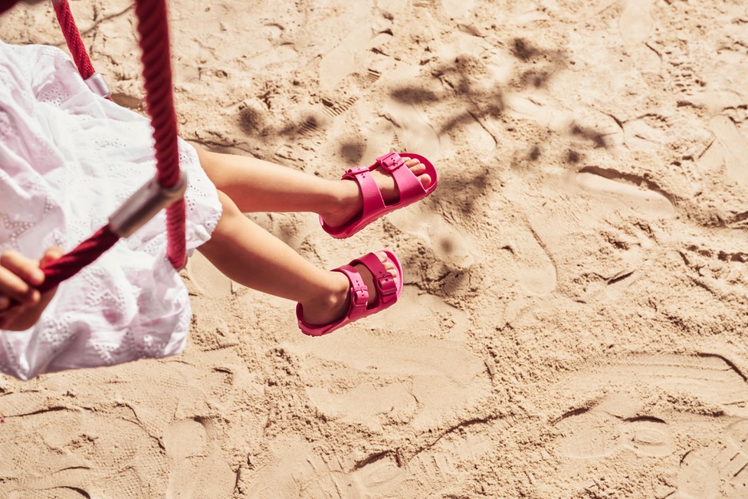 child wearing beetroot EVA birkenstock sandals at beach